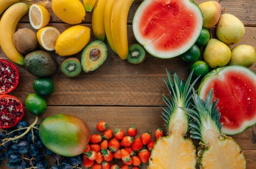 Colorful assortment of fresh fruits in a flatlay on wooden surface, perfect for healthy lifestyle themes.